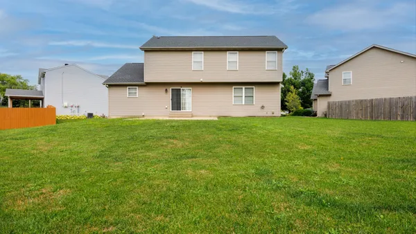 front view of a house with a yard and a trees