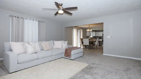 a living room with furniture and a ceiling fan