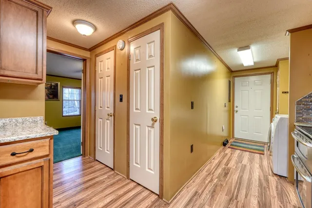 a view of a hallway with wooden floor and staircase