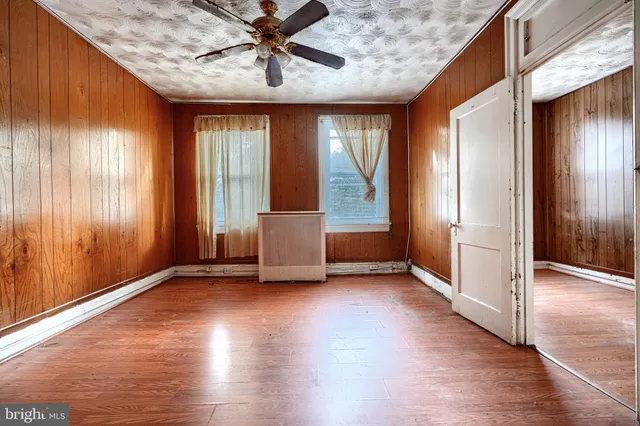 a view of a hallway with wooden floor and entryway
