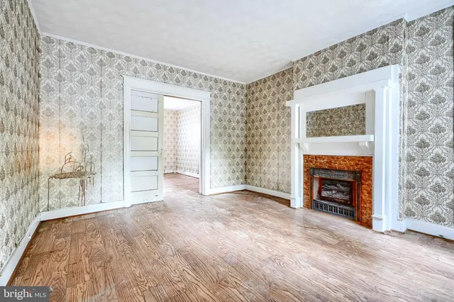 wooden floor fireplace and windows in an empty room