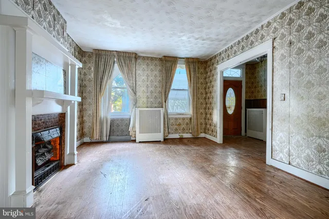 an empty room with windows and a fireplace