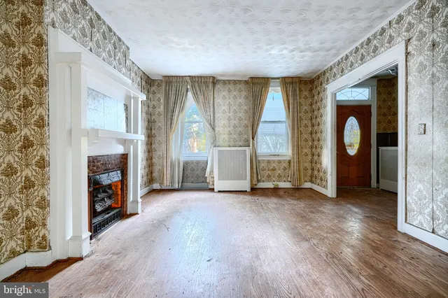 wooden floor fireplace and windows in an empty room