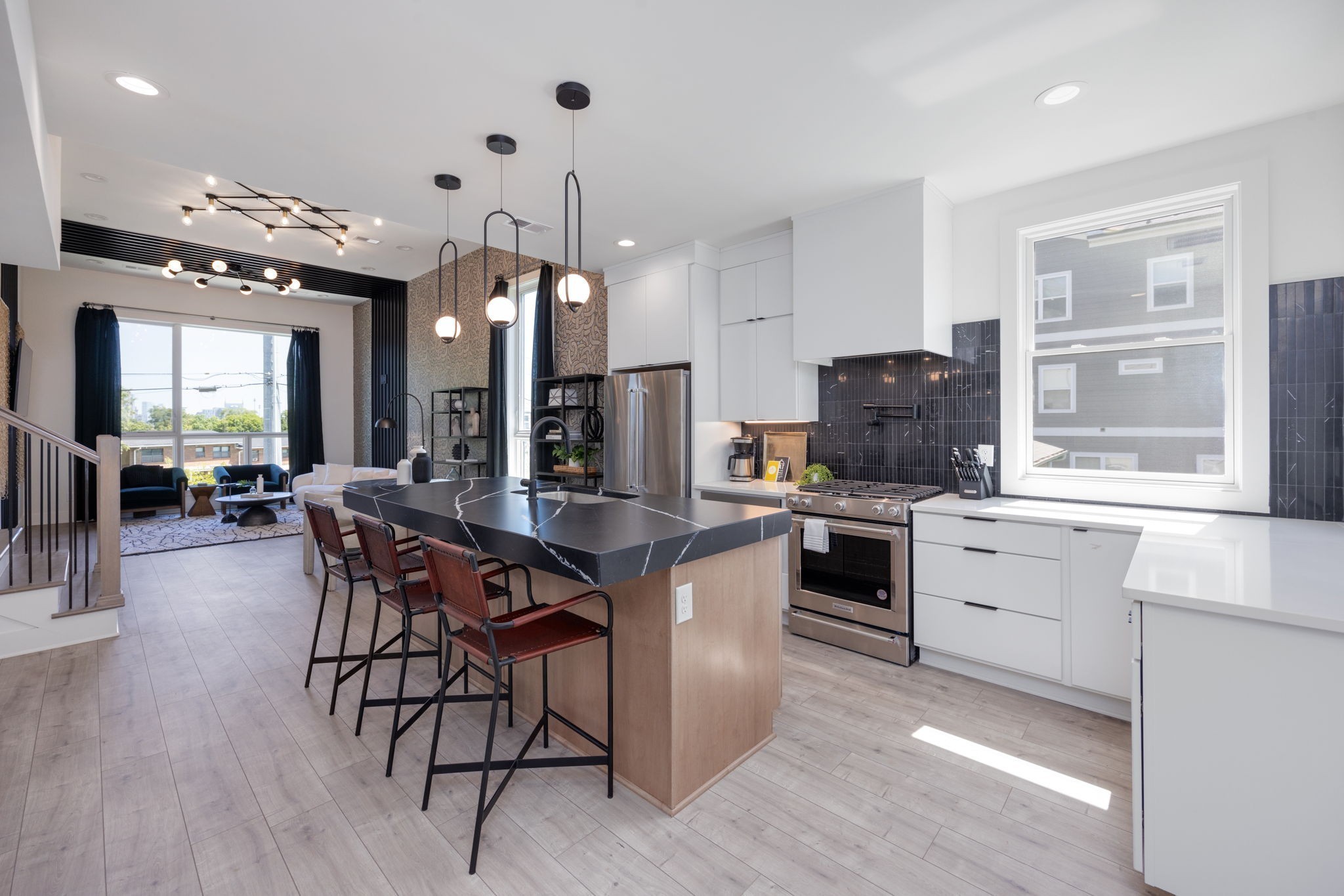 a kitchen with stainless steel appliances kitchen island granite countertop a stove a sink a refrigerator and a dining table with wooden floor