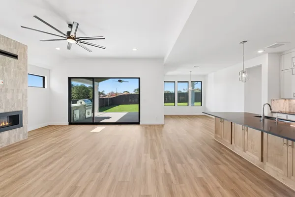 a view of an empty room with window and wooden floor