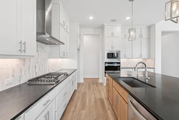 a kitchen with stainless steel appliances granite countertop a sink stove and refrigerator