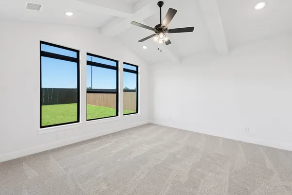 an empty room with windows and fan