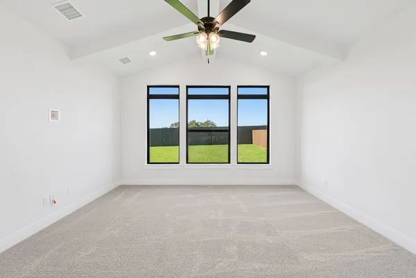 an empty room with windows and fan