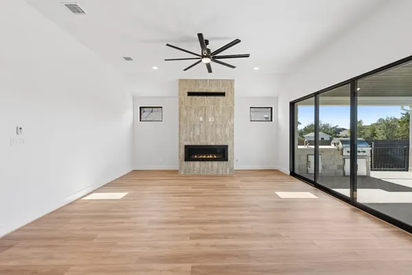a view of an empty room with a fireplace and window