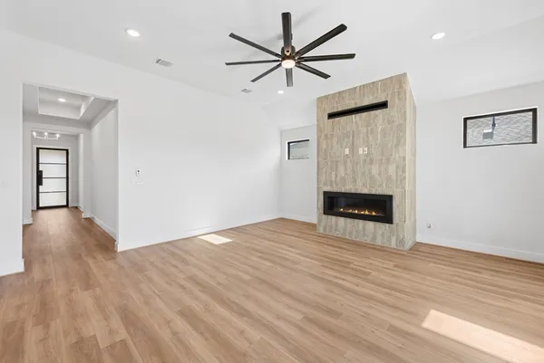 a view of empty room with wooden floor and fireplace
