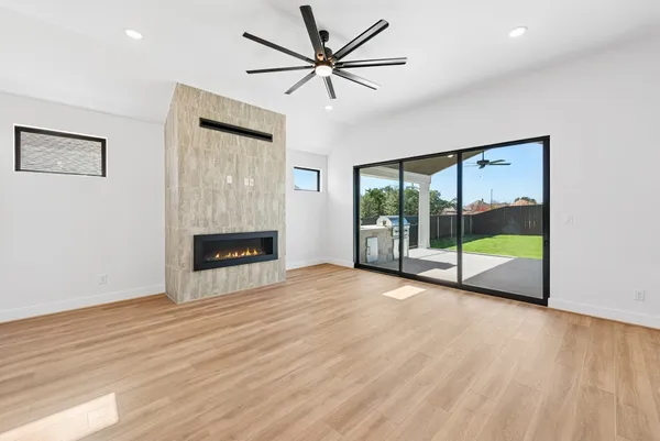 a view of an empty room with a fireplace and a window