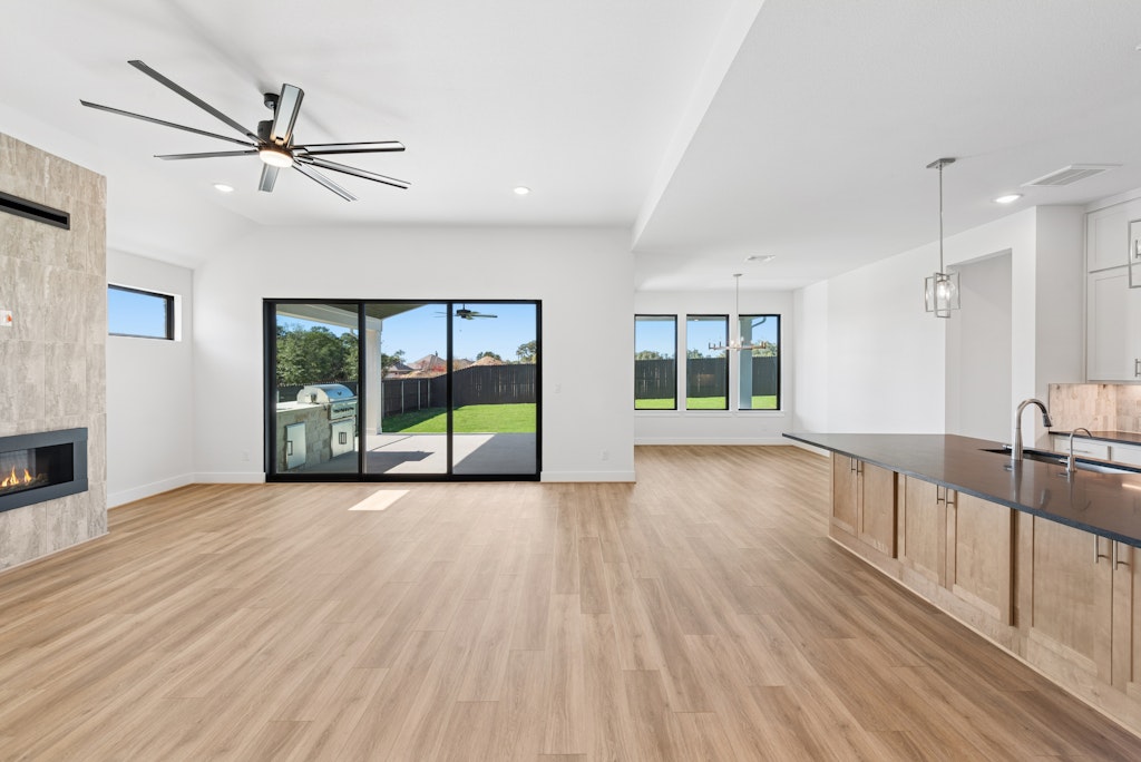 3408 Emerald Lake Path Georgetown, TX 78628 - Photo 10 of 38 a view of a livingroom with furniture wooden floor a ceiling fan and windows