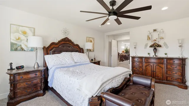 a bedroom with a bed and a flat tv screen on dresser
