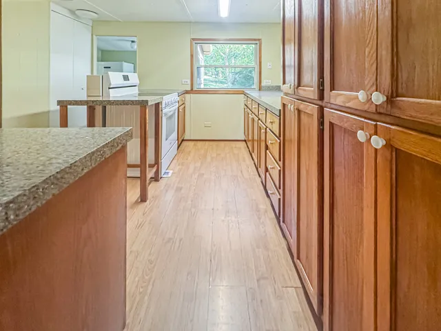 a view of a kitchen with wooden floor and windows