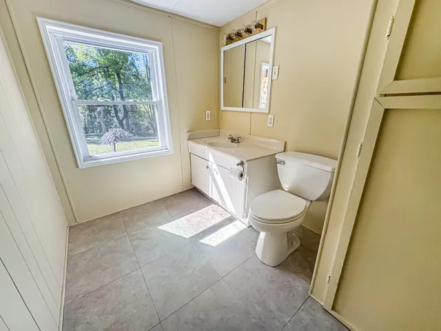 a bathroom with a toilet sink and mirror