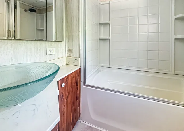 a bathroom with a tub a sink and a shower