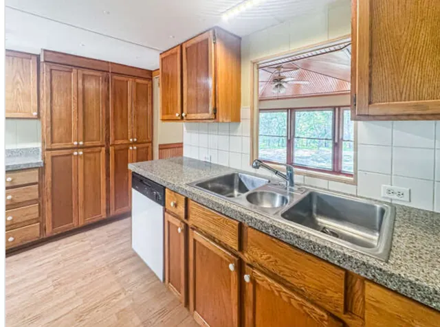 a kitchen with stainless steel appliances granite countertop a sink and a granite counter tops with wooden floors