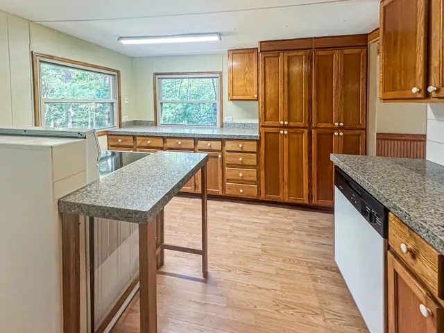 a kitchen with granite countertop a stove a sink and a refrigerator