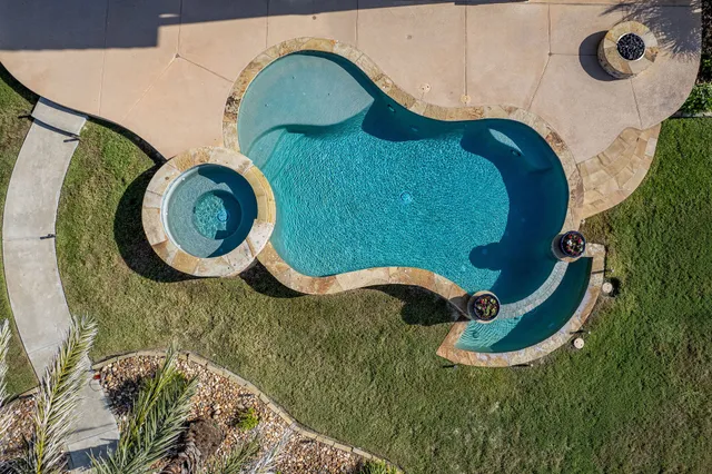 an aerial view of a house with swimming pool and outdoor space