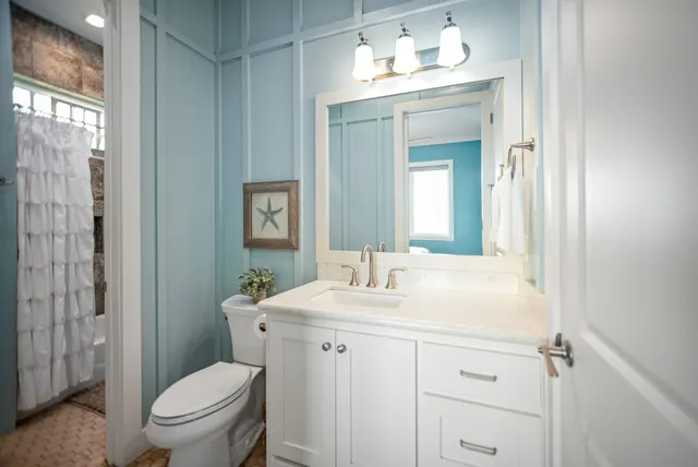 a bathroom with a granite countertop sink toilet a large mirror a vanity and shower