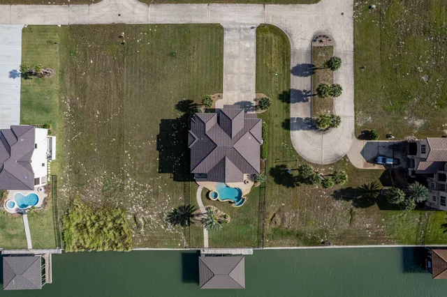 an aerial view of a residential houses with yard
