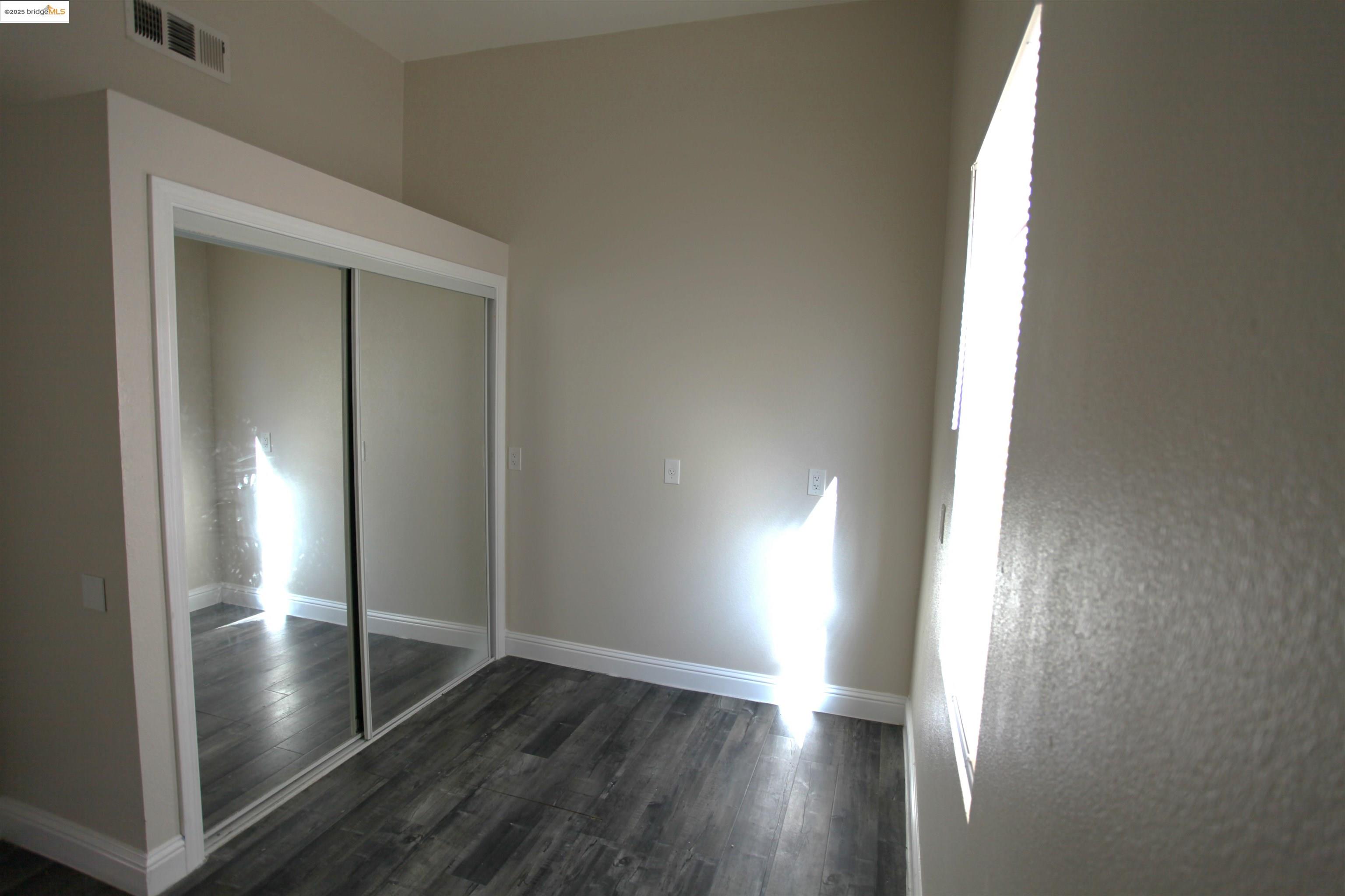 50 Main Street Isleton, CA 95641 - Photo 14 of 59 an empty room with wooden floor mirror and windows