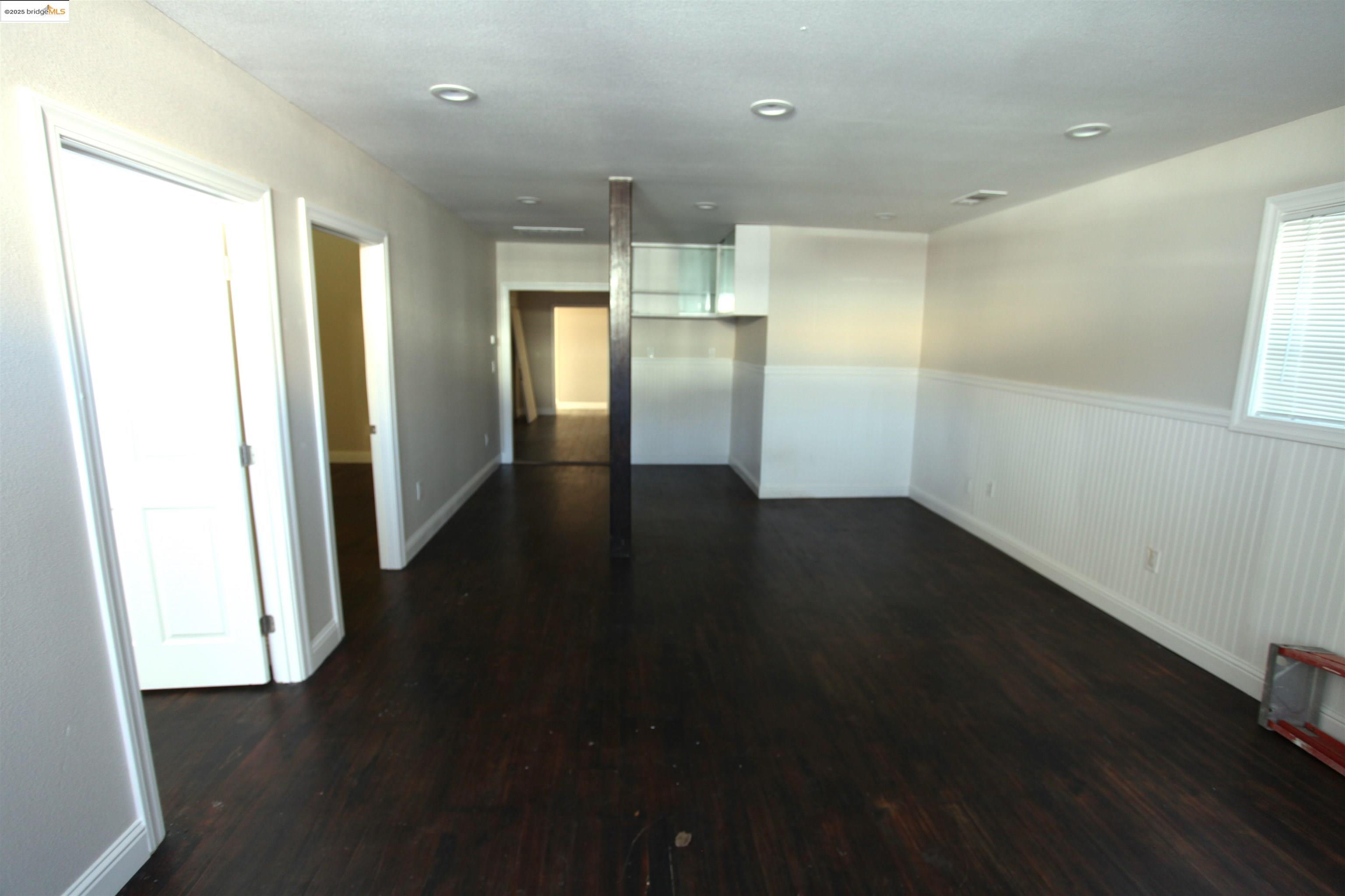 50 Main Street Isleton, CA 95641 - Photo 2 of 59 an empty room with wooden floor staircase and windows