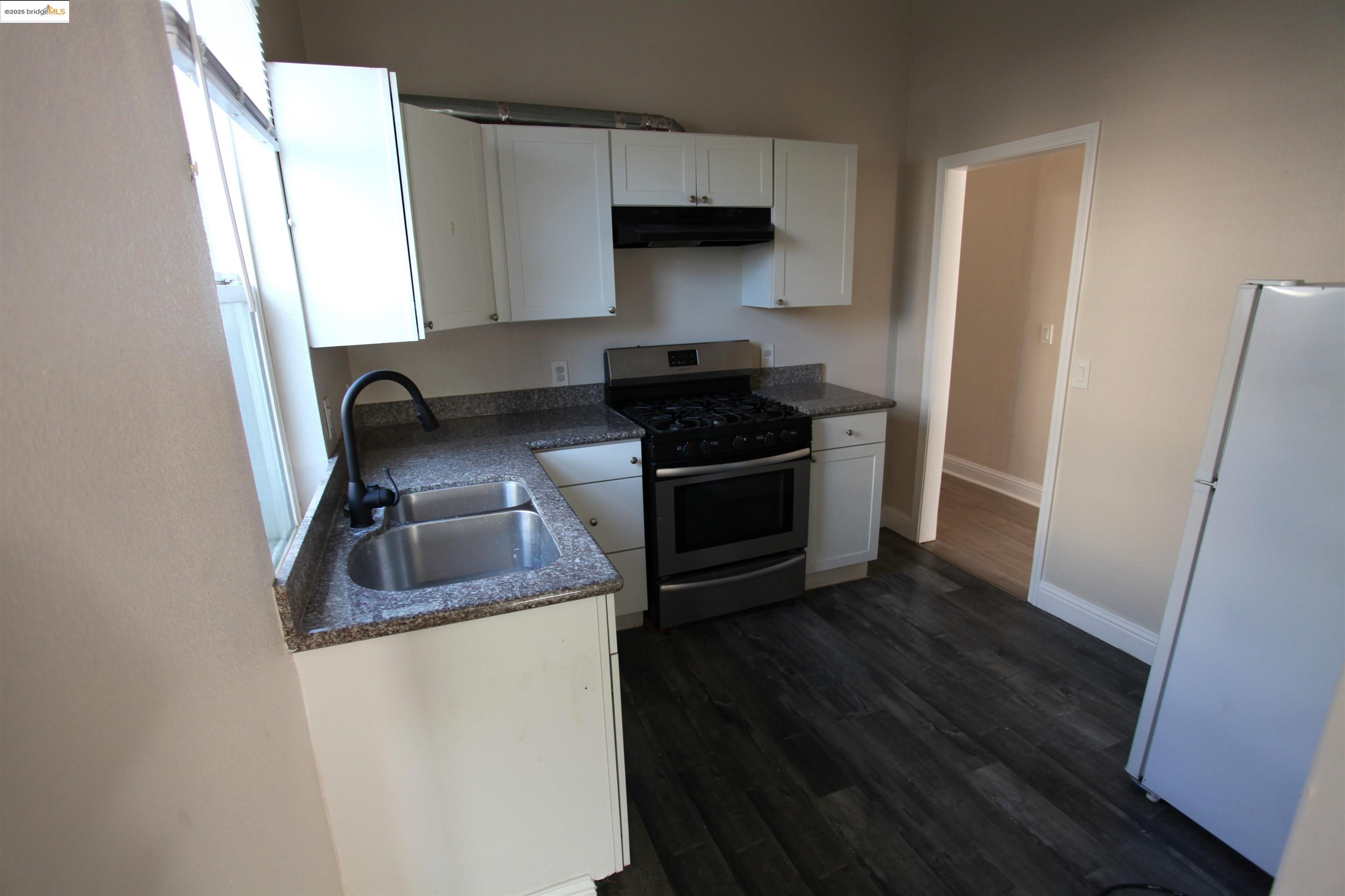 50 Main Street Isleton, CA 95641 - Photo 21 of 59 a kitchen with granite countertop a stove and a refrigerator