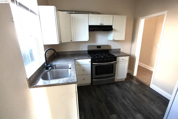 a kitchen with a wooden floor and a stove top oven