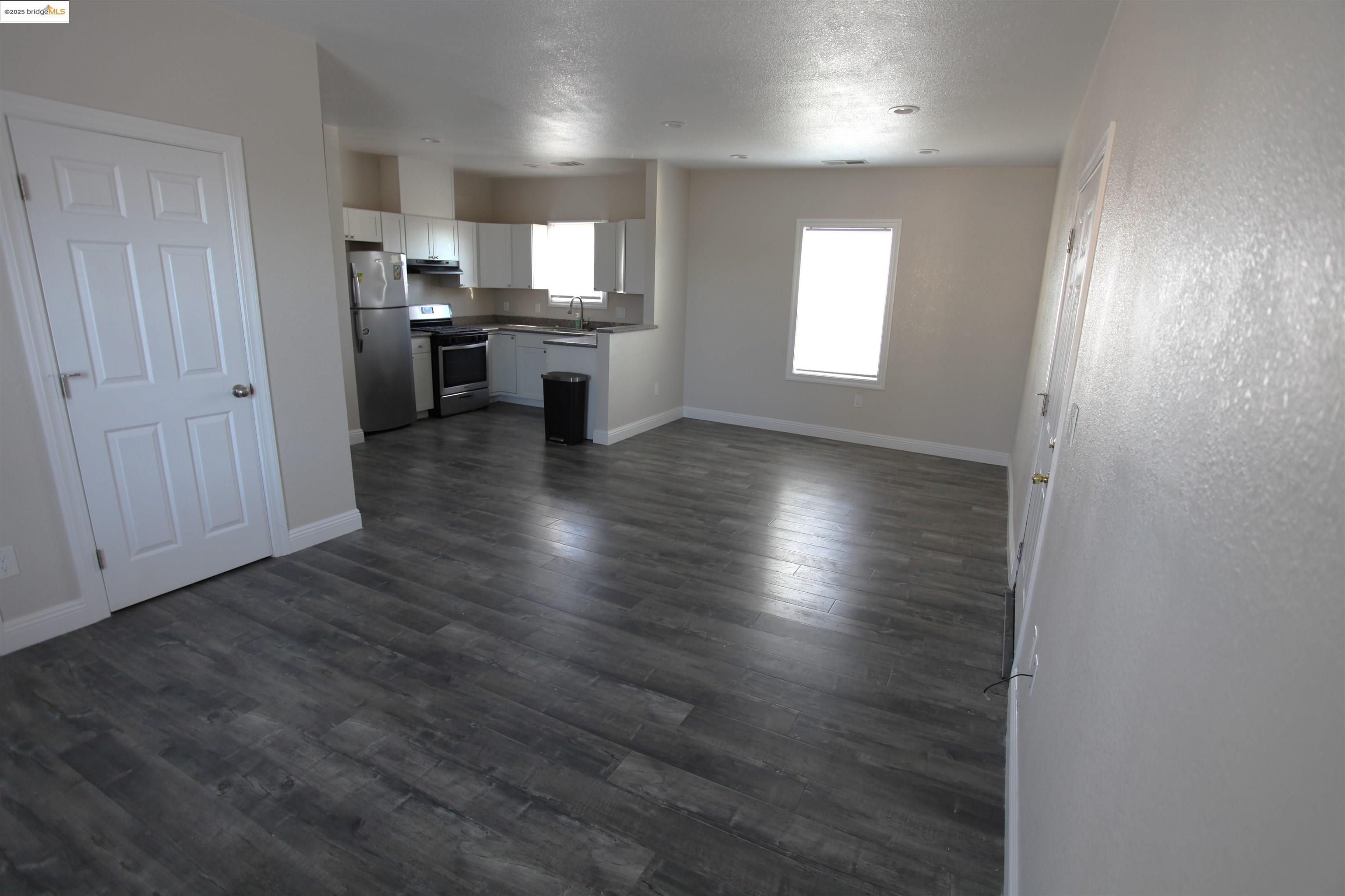 50 Main Street Isleton, CA 95641 - Photo 31 of 59 an empty room with wooden floor cabinet and windows