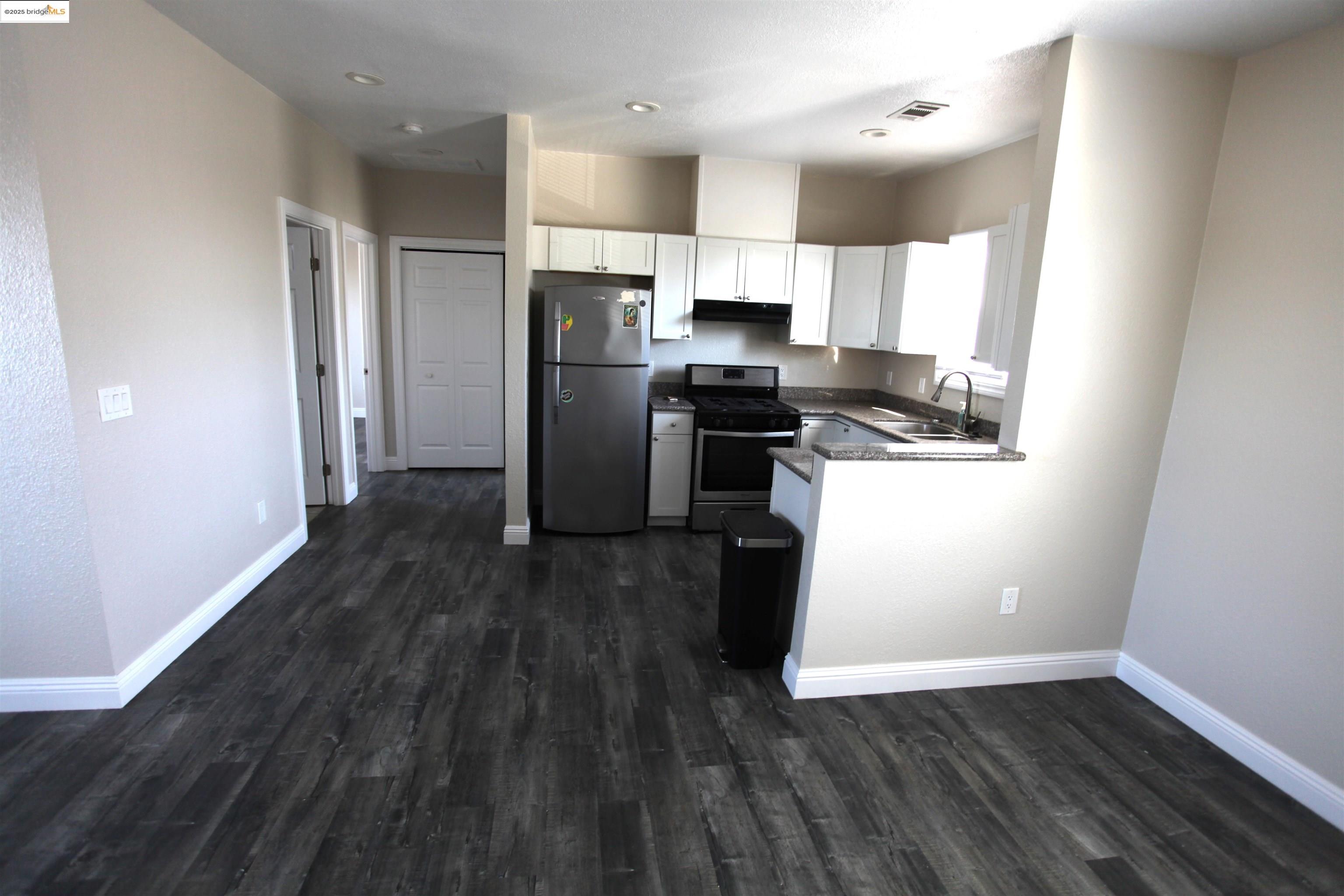 50 Main Street Isleton, CA 95641 - Photo 33 of 59 a kitchen with a refrigerator a stove top oven and wooden floor