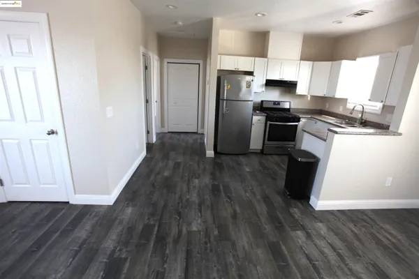 a kitchen with a refrigerator and a stove top oven