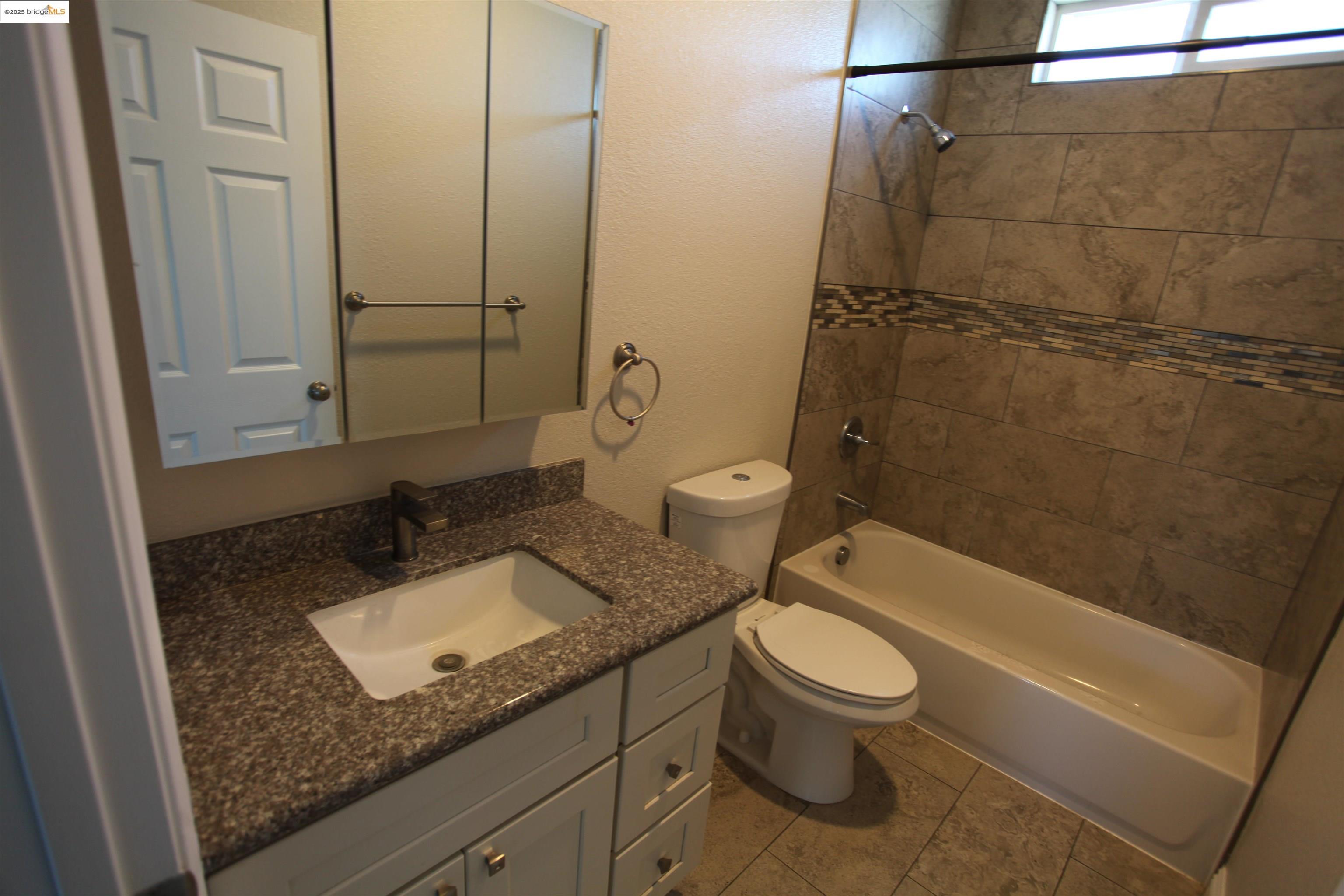 50 Main Street Isleton, CA 95641 - Photo 40 of 59 a bathroom with a granite countertop toilet a sink and bathtub