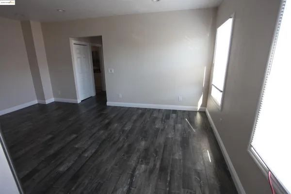 an empty room with wooden floor and closet