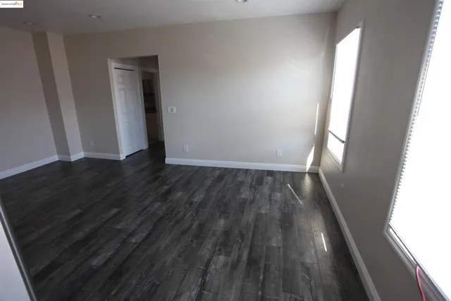 an empty room with wooden floor and closet
