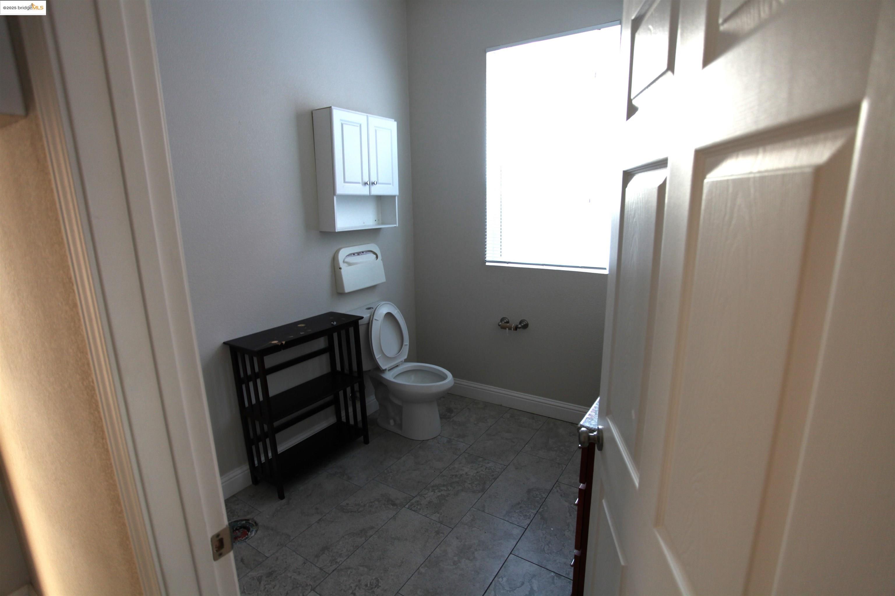 50 Main Street Isleton, CA 95641 - Photo 8 of 59 a bathroom with a toilet a sink and mirror