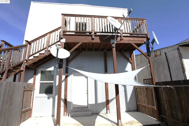 an empty room with wooden floor mirror and windows