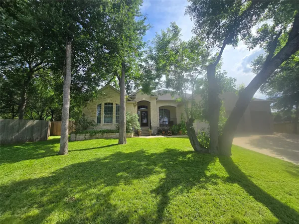 a view of house with a backyard