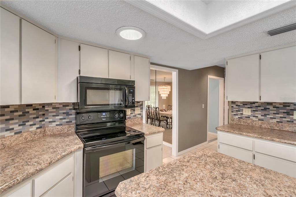 8156 Southwest 108th Ln Road Ocala, FL 34481 - Photo 11 of 50 a kitchen with a stove and a microwave