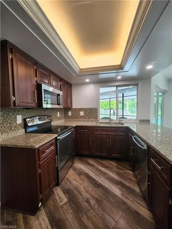 a kitchen with granite countertop wooden cabinets and stainless steel appliances