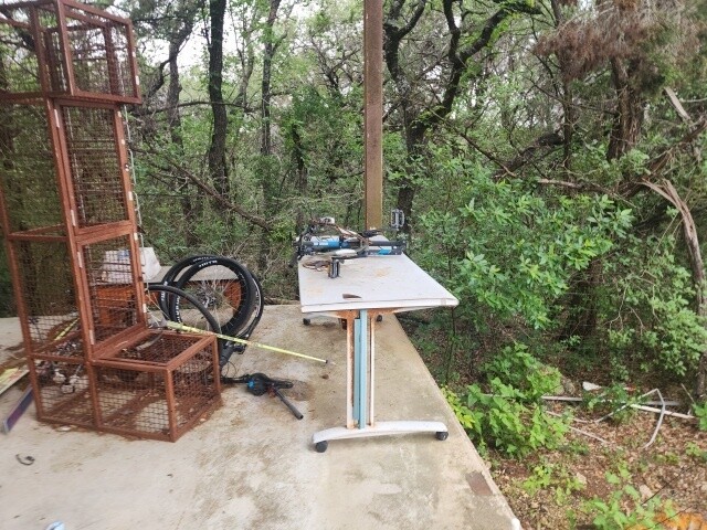12011 Buckner Road Austin, TX 78726 - Photo 21 of 40 An outdoor workspace overlooks a serene, wooded landscape.