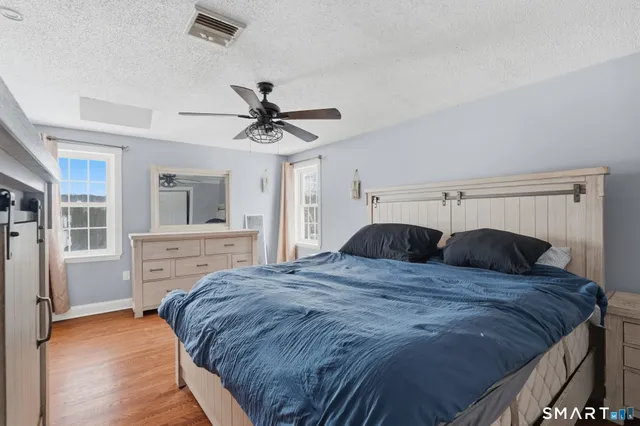 a large bedroom with a bed and wooden floor