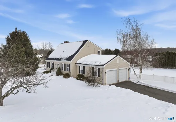 a front view of a house with a yard covered in snow