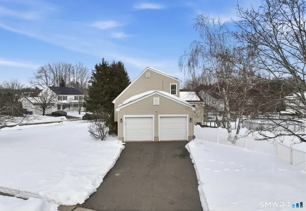 a front view of a house with a yard covered in snow