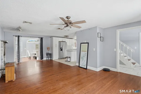 a view of an empty room with window and wooden floor