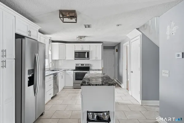 a kitchen with stainless steel appliances granite countertop a refrigerator and a stove