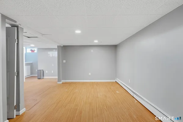 a view of a big room with wooden floor and windows
