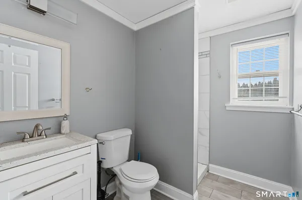 a bathroom with a granite countertop toilet and sink