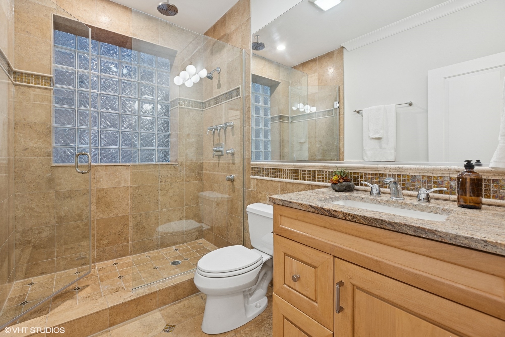 1035 West Monroe Street, Unit 1 Chicago, IL 60607 - Photo 13 of 27 a bathroom with a granite countertop sink a toilet a mirror and shower