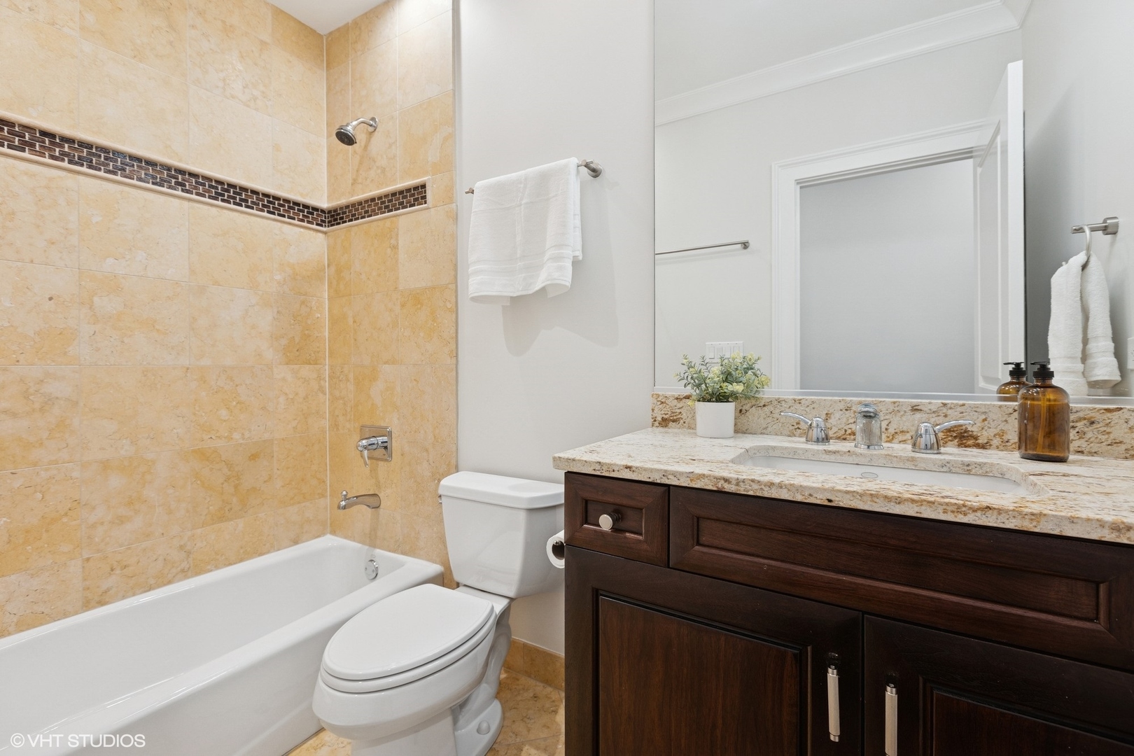 1035 West Monroe Street, Unit 1 Chicago, IL 60607 - Photo 19 of 27 a bathroom with a granite countertop sink toilet a large mirror a bathtub and shower